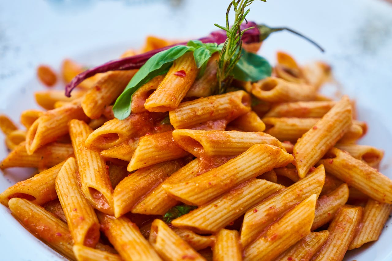 heros-img Savor the flavors of Italian cuisine with this close-up photo of tasty penne pasta in tomato sauce.